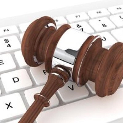 photograph of a brown wooden gavel laid on a white keyboard